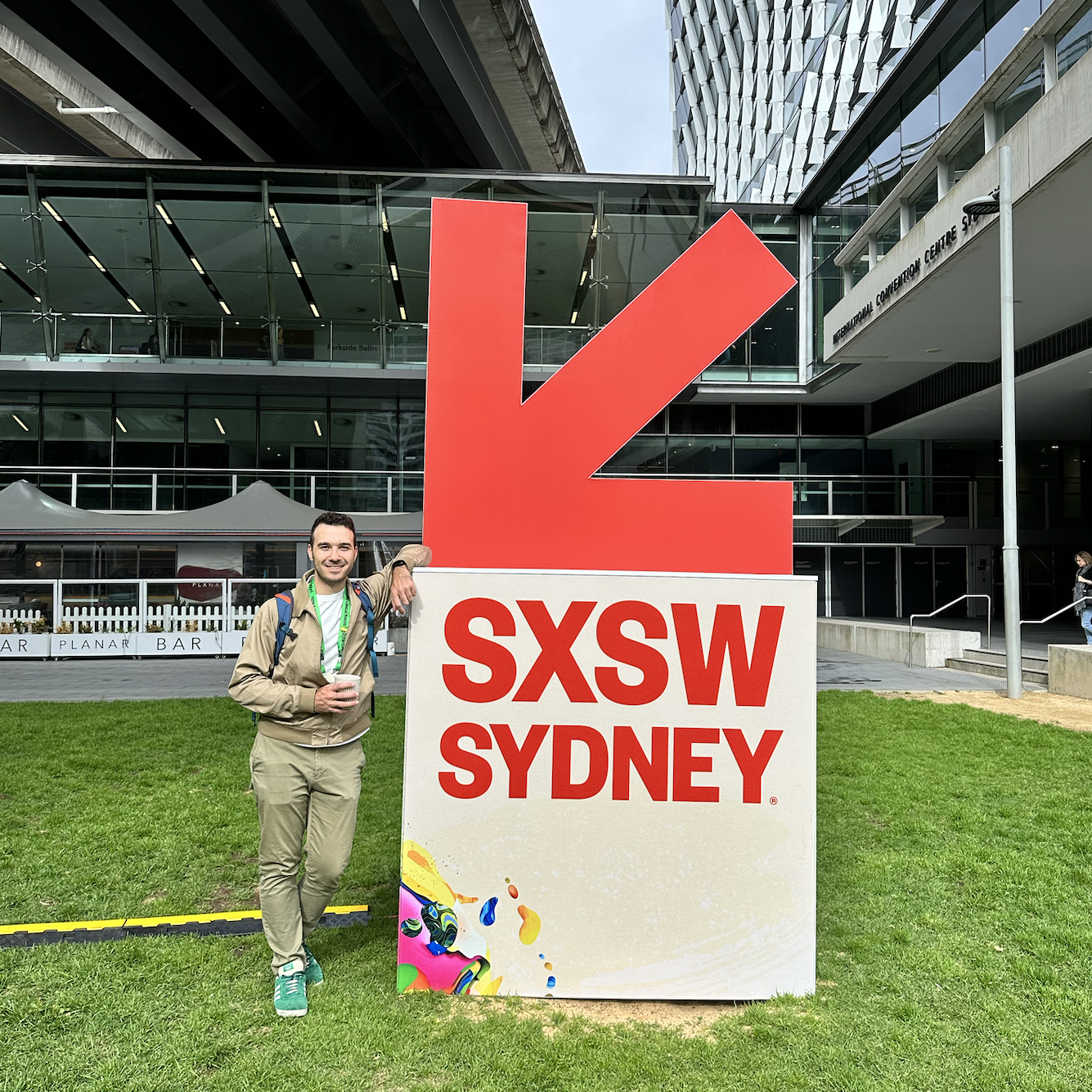 Victor standing next to a sign for the first South by Southwest Sydney.
